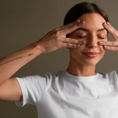 Vrouw doet gezichtsyoga oefening in wit shirt