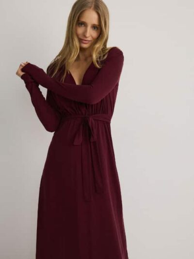 vrouw met bordeaurode jurk met lange mouwen
