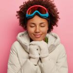 vrouw met winterkleding, skibril en handschoenen