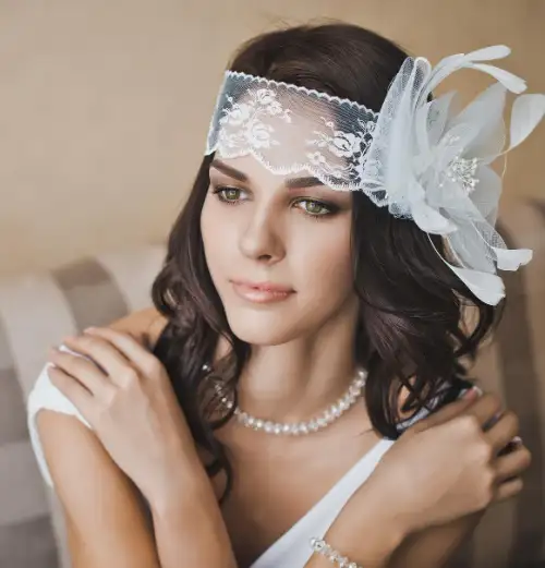 Vrouw met kanten hoofddeksel en elegante sieraden.