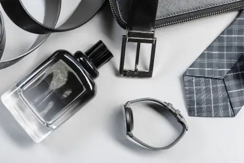 Parfumfles en accessoires voor mannen op wit achtergrond.