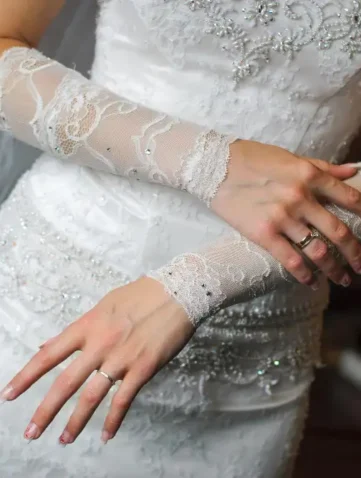 Bruidsjurk met kanten handschoenen en sierlijke details