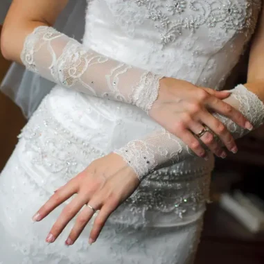 Bruidsjurk met kanten handschoenen en sierlijke details