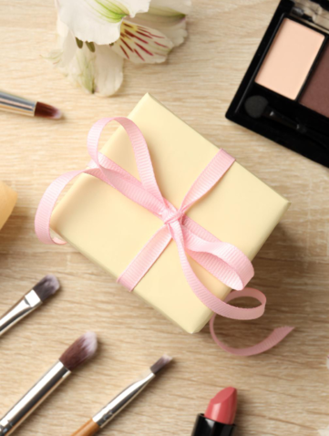 Cadeau met make-up en bloemen op tafel