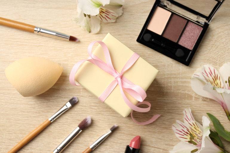 Cadeau met make-up en bloemen op tafel