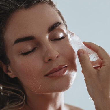 Vrouw doet aan skin icing met ijsblok op gezicht
