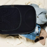 Open soft underseatbag met kleding en bril eruit.