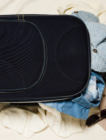Open soft underseatbag met kleding en bril eruit.