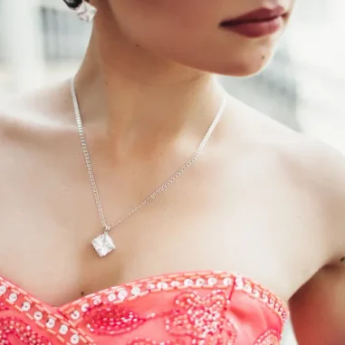 vrouw met rode topless jurk en diamanten ketting
