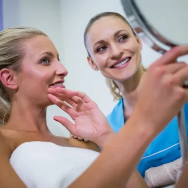 twee vrouwen met spiegel bespreken resultaat huidbehandeling