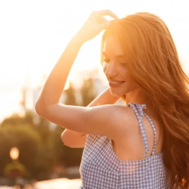 Vrouw met lang rood haar in de zon