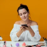 vrouw met mobiel en verzorgingsproducten voor zich