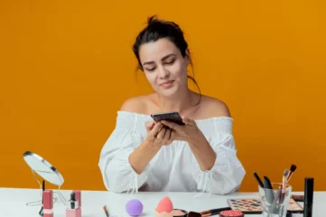 vrouw met mobiel en verzorgingsproducten voor zich