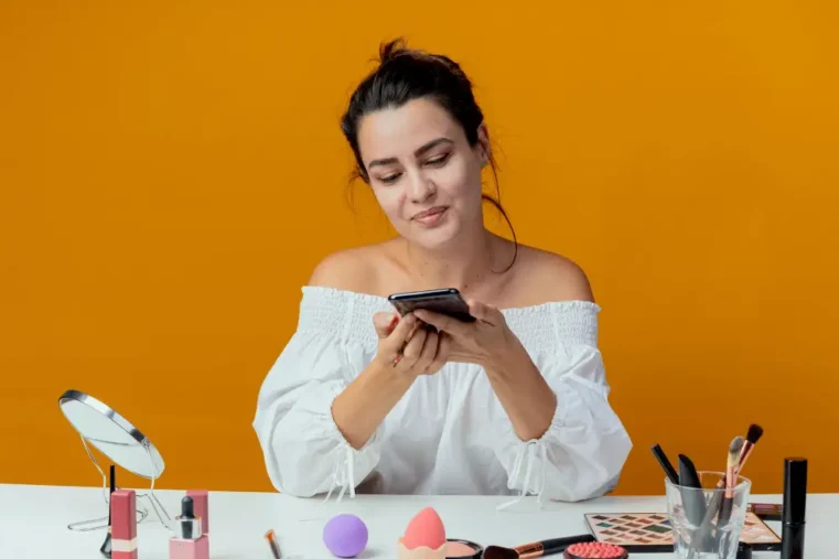vrouw met mobiel en verzorgingsproducten voor zich