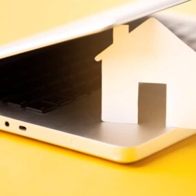 laptop met houten huis ertussen