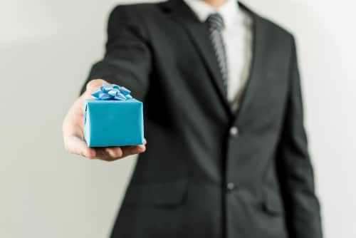 man in pak geeft geschenk
