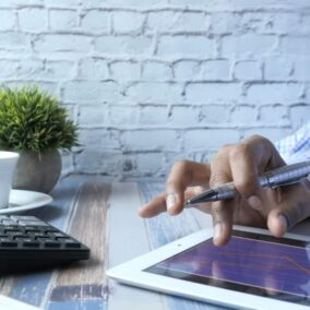 man op tablet met rekenmachine