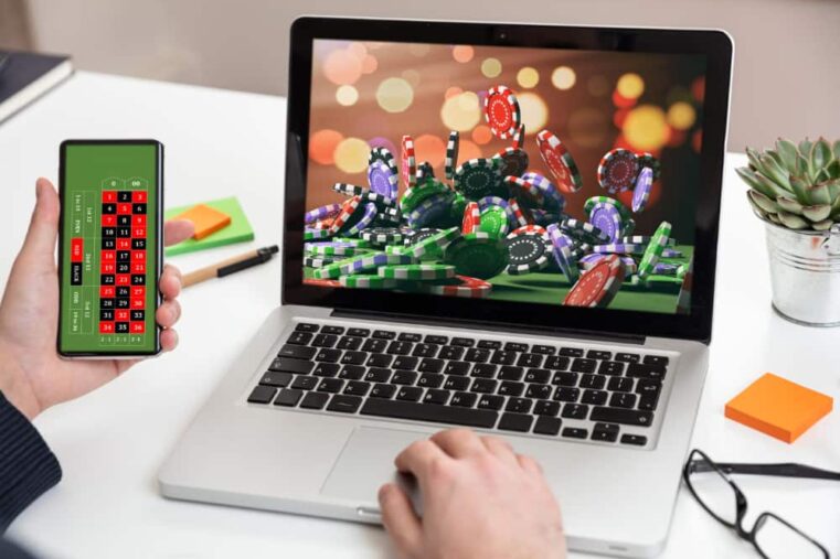 man gamed op laptop en mobiel