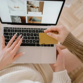 vrouw achter laptop met betaalpas