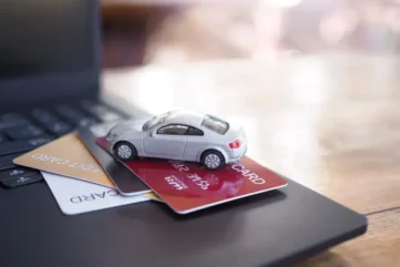 laptop met betaalpassen en miniatuur auto