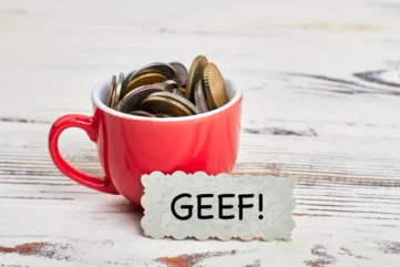 Kopje met geld en bordje ervoor met Geef!