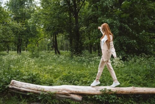 vrouw zoek evenwicht op boomstam