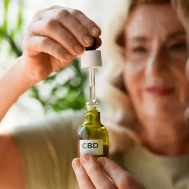 vrouw met flesje cbd olie met pipet