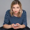 vrouw kijkt somber met mobiel in de hand