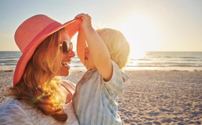 jonge moeder met kind aan een zonnig strand