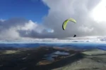 Parapente boven kust met meren en wolken
