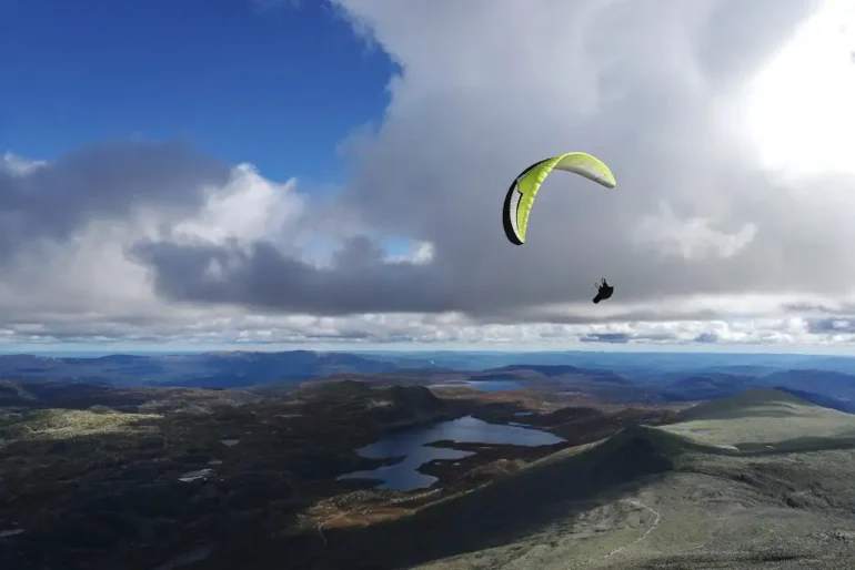 Parapente boven kust met meren en wolken