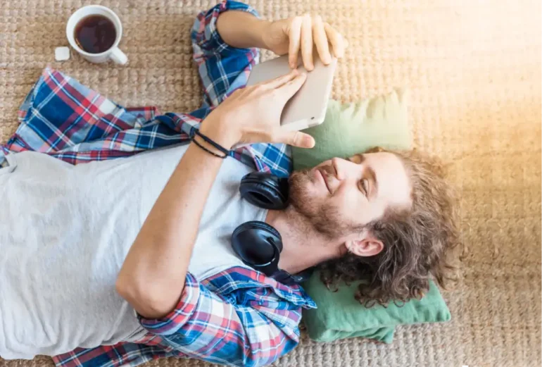 Man ontspannen met koptelefoon en tablet op kleed