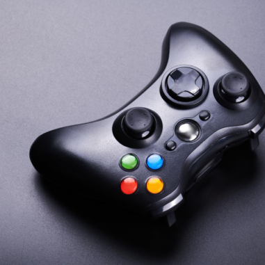 Zwarte gamecontroller met kleurrijke knoppen op tafel.