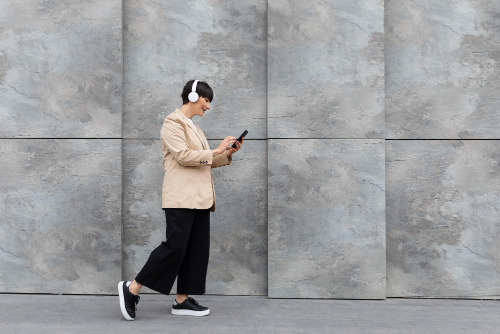 Persoon wandelt met koptelefoon en smartphone