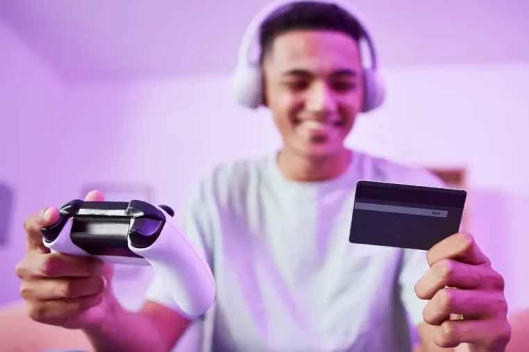 Spelende man met gift card en koptelefoon