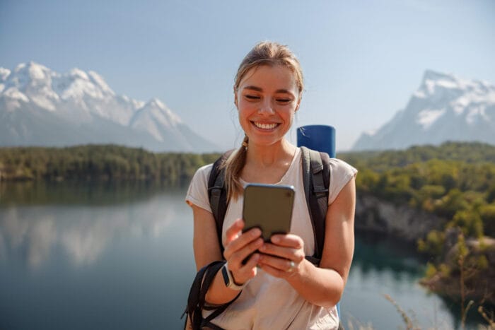 Vrouw met mobiele telefoon in bergen