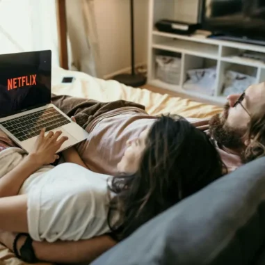 Stel kijkt Netflix op laptop in bed