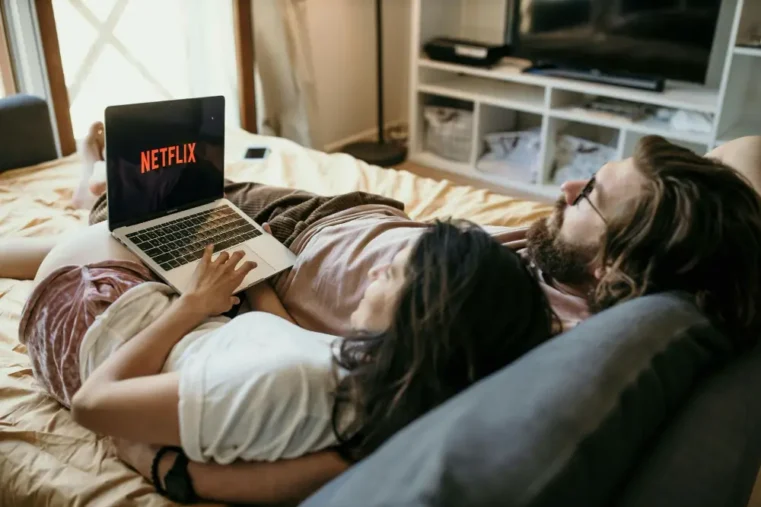 Stel kijkt Netflix op laptop in bed