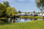 vakantiepark aan een meer en kinderen die spelen op de voorgrond