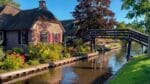 Een rietgedekt huis aan het water met brug in Giethoorn