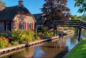 Een rietgedekt huis aan het water met brug in Giethoorn
