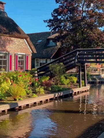 Een rietgedekt huis aan het water met brug in Giethoorn