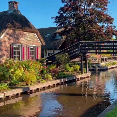 Een rietgedekt huis aan het water met brug in Giethoorn