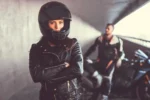 vrouw met helm en motorkleding en man met motor