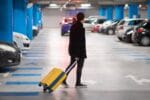 Man met koffer loopt door parkeergarage