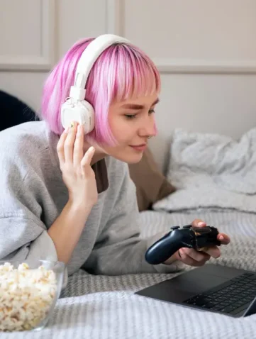 vrouw vermaakt zich online op laptop met schaal popcorn