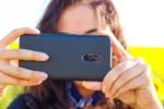 Persoon fotografeert buiten met smartphone in liggende stand