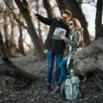 man en vrouw kijken op kaart tijdens date in een bos