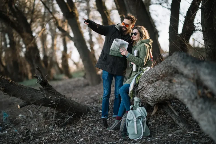 man en vrouw kijken op kaart tijdens date in een bos
