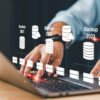 man achter laptop doet aan database beheer